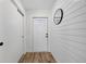 Bright entryway featuring a modern front door, wood-look floors, and shiplap accent wall with a round mirror at 2733 Riverbluff Pl # V57, Sarasota, FL 34231