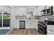 Modern kitchen with white cabinets, stainless steel appliances, and wood-look flooring at 2733 Riverbluff Pl # V57, Sarasota, FL 34231