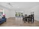 Open-concept living room featuring wood-look floors, a ceiling fan, and sliding doors to the outdoor patio at 2733 Riverbluff Pl # V57, Sarasota, FL 34231