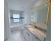Bright bathroom with marble floors, white cabinets, and a gold-trimmed mirror at 2881 Pope St, North Port, FL 34287