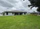 Rear exterior view of the house showing a large backyard and screen enclosure at 2881 Pope St, North Port, FL 34287