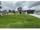 Beautifully landscaped home featuring a well-maintained lawn and modern architectural details at 2881 Pope St, North Port, FL 34287