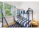 Cozy bedroom features a comfortable bunk bed, nautical accents, and a sunlit window at 307B 63Rd St, Holmes Beach, FL 34217