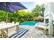 Resort-style backyard with a refreshing pool, inviting patio furniture, and lush tropical landscaping at 307B 63Rd St, Holmes Beach, FL 34217
