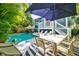 Inviting pool area with ample patio seating, tropical landscaping, and a serene backyard ambiance at 307B 63Rd St, Holmes Beach, FL 34217
