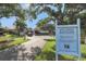 Entrance to Village Brooke Condominiums with lush greenery and mature trees at 3269 Beneva Rd # 203, Sarasota, FL 34232