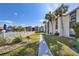 View of condos with tropical landscaping, walkway, and a glimpse of the community pool at 3269 Beneva Rd # 203, Sarasota, FL 34232