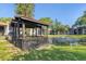 Gazebo on the edge of a pond with fountain surrounded by green grass and tropical plants at 3269 Beneva Rd # 203, Sarasota, FL 34232