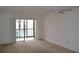 Bright living room with neutral carpet, ceiling fan, and sliding glass doors to the pool area at 3269 Beneva Rd # 203, Sarasota, FL 34232