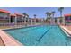 Beautiful swimming pool surrounded by palm trees and well-maintained condos with red tile roofs at 3269 Beneva Rd # 203, Sarasota, FL 34232