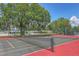 Close-up view of the community tennis court, showcasing the net and court lines in a lush outdoor setting at 3269 Beneva Rd # 203, Sarasota, FL 34232
