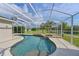 Sparkling screened-in pool with tranquil waterfall feature, integrated spa, and well-maintained patio at 3309 45Th E Ave, Bradenton, FL 34203