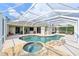 Beautiful screened-in pool with waterfall, integrated spa, spacious patio, and manicured lawn at 3309 45Th E Ave, Bradenton, FL 34203