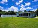 Expansive backyard featuring lush lawn, enclosed sunroom, and classic white picket fence at 3600 Wisteria Pl, Punta Gorda, FL 33950