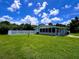 Expansive backyard featuring lush lawn, enclosed sunroom, and classic white picket fence at 3600 Wisteria Pl, Punta Gorda, FL 33950