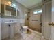 Bathroom featuring a pedestal sink, tiled shower, and updated fixtures at 3600 Wisteria Pl, Punta Gorda, FL 33950