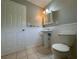 Bathroom with a pedestal sink, wainscoting, and tile flooring at 3600 Wisteria Pl, Punta Gorda, FL 33950
