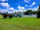 Charming home featuring a white picket fence, beautiful lawn, and blue skies overhead at 3600 Wisteria Pl, Punta Gorda, FL 33950