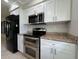 Modern kitchen features white cabinets, stainless steel appliances, granite countertops, and ample storage at 3600 Wisteria Pl, Punta Gorda, FL 33950
