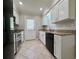 Well-lit kitchen with white cabinets, stainless steel appliances, granite countertops, and tile flooring at 3600 Wisteria Pl, Punta Gorda, FL 33950