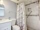 Bathroom featuring marble tiled shower with pebble floor, marble vanity and a decorative shower curtain at 3702 Lake Bayshore K-412 Dr # 412, Bradenton, FL 34205