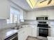 Bright kitchen features white cabinets, stainless steel appliances, and a window with a view at 3702 Lake Bayshore K-412 Dr # 412, Bradenton, FL 34205