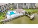 Aerial view of the community pool and dock on the water with lounge chairs and tables at 3702 Lake Bayshore K-412 Dr # 412, Bradenton, FL 34205