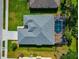 Aerial view of a single-Gathering home featuring a screened-in pool, well-maintained lawn, and a modern gray roof at 3718 61St E Dr, Bradenton, FL 34203
