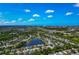 Expansive aerial shot showcasing a residential community with lush green landscapes and serene lakes under a blue sky at 3718 61St E Dr, Bradenton, FL 34203