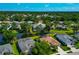 Aerial view showcases a lakeside home with a screened pool, palm trees, and lush landscaping at 3718 61St E Dr, Bradenton, FL 34203