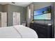 Stylish bedroom with a sleek dresser and a large flat-screen TV displaying a tropical beach scene at 3806 72Nd E Ter, Sarasota, FL 34243