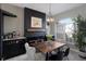 Stylish dining area with modern chandelier, fireplace, and a view of the landscaped backyard through the window at 3806 72Nd E Ter, Sarasota, FL 34243