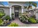 Inviting home entrance features a covered archway, lush landscaping, and brick pathway at 3806 72Nd E Ter, Sarasota, FL 34243