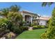 Single-story home with an arched entryway, tidy landscaping and green lawn on a sunny day at 3806 72Nd E Ter, Sarasota, FL 34243