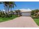 Charming single-Gathering home showcasing a beautiful tiled roof, lush landscaping, and a brick driveway at 3806 72Nd E Ter, Sarasota, FL 34243