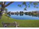 Scenic pond view showcasing lush landscaping and serene reflections of homes in the neighborhood at 3806 72Nd E Ter, Sarasota, FL 34243