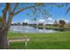 Picturesque pond view from the community lawn with bench seating and lush landscaping at 3806 72Nd E Ter, Sarasota, FL 34243