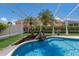 Screened-in pool area with palm trees, rock features, and privacy landscaping at 3806 72Nd E Ter, Sarasota, FL 34243
