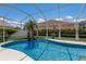 Private backyard swimming pool area with screened enclosure and tropical plants at 3806 72Nd E Ter, Sarasota, FL 34243