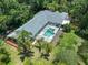 Aerial view of a home with a screened-in pool, surrounded by mature trees and lush landscaping offering privacy at 3919 Fan Palm Ct, Land O Lakes, FL 34638