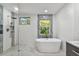 Elegant bathroom featuring a soaking tub, shower, and dual windows providing natural light at 3919 Fan Palm Ct, Land O Lakes, FL 34638