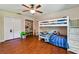Cozy bedroom with bunk beds, laminate flooring, ceiling fan, closet, and bright natural light at 3919 Fan Palm Ct, Land O Lakes, FL 34638