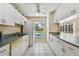 Galley kitchen with white cabinets and appliances looking out onto the screened pool at 3919 Fan Palm Ct, Land O Lakes, FL 34638