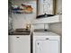 Laundry room with Maytag washer and dryer, shelf with basket and view of hot water heater at 3919 Fan Palm Ct, Land O Lakes, FL 34638