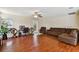 Spacious living room with a ceiling fan, dark laminate flooring, and dark brown couches at 3919 Fan Palm Ct, Land O Lakes, FL 34638
