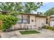Inviting home exterior with a small seating area, complemented by vibrant plants and a well-maintained front yard at 4023 Chestnut Ave, Sarasota, FL 34234