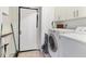 Functional laundry room with washer, dryer, and overhead cabinets at 4023 Chestnut Ave, Sarasota, FL 34234