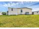Rear exterior view of the home, showcasing the siding, an AC unit, and green lawn at 4119 13Th E St, Ellenton, FL 34222