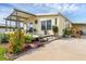 Inviting home featuring a covered porch, lovely patio, and a beautifully landscaped yard with plants and trees at 4119 13Th E St, Ellenton, FL 34222