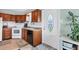 Cozy kitchen features wood cabinetry, white appliances, and an adjacent entry door at 4119 13Th E St, Ellenton, FL 34222